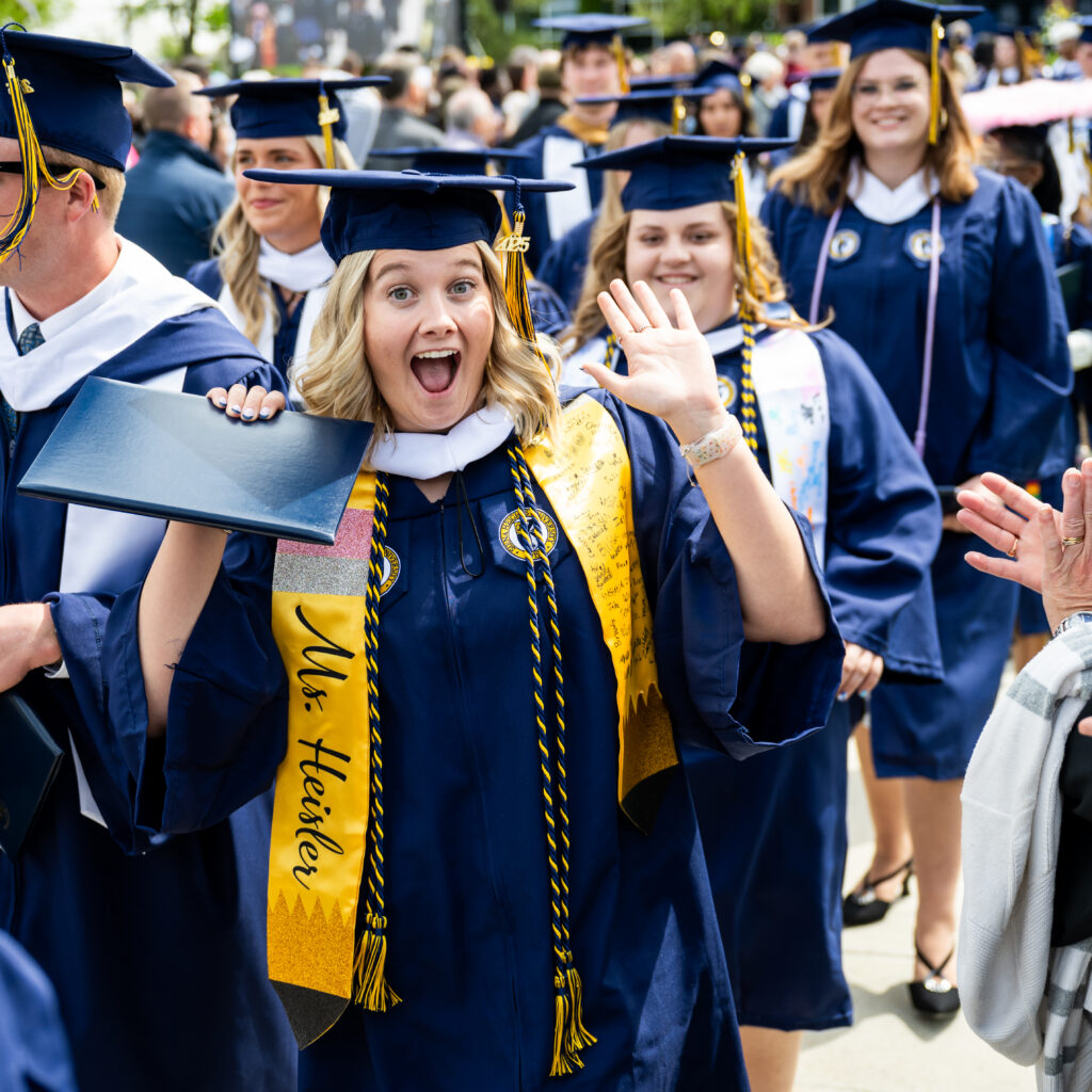 Siena Heights University Residential 2025 Commencement. Happy graduate with hands in the air.