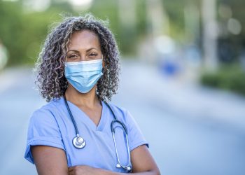 Portrait of an African American nurse wearing a protective face mask to avoid the transfer of germs during the COVID-19 outbreak.
